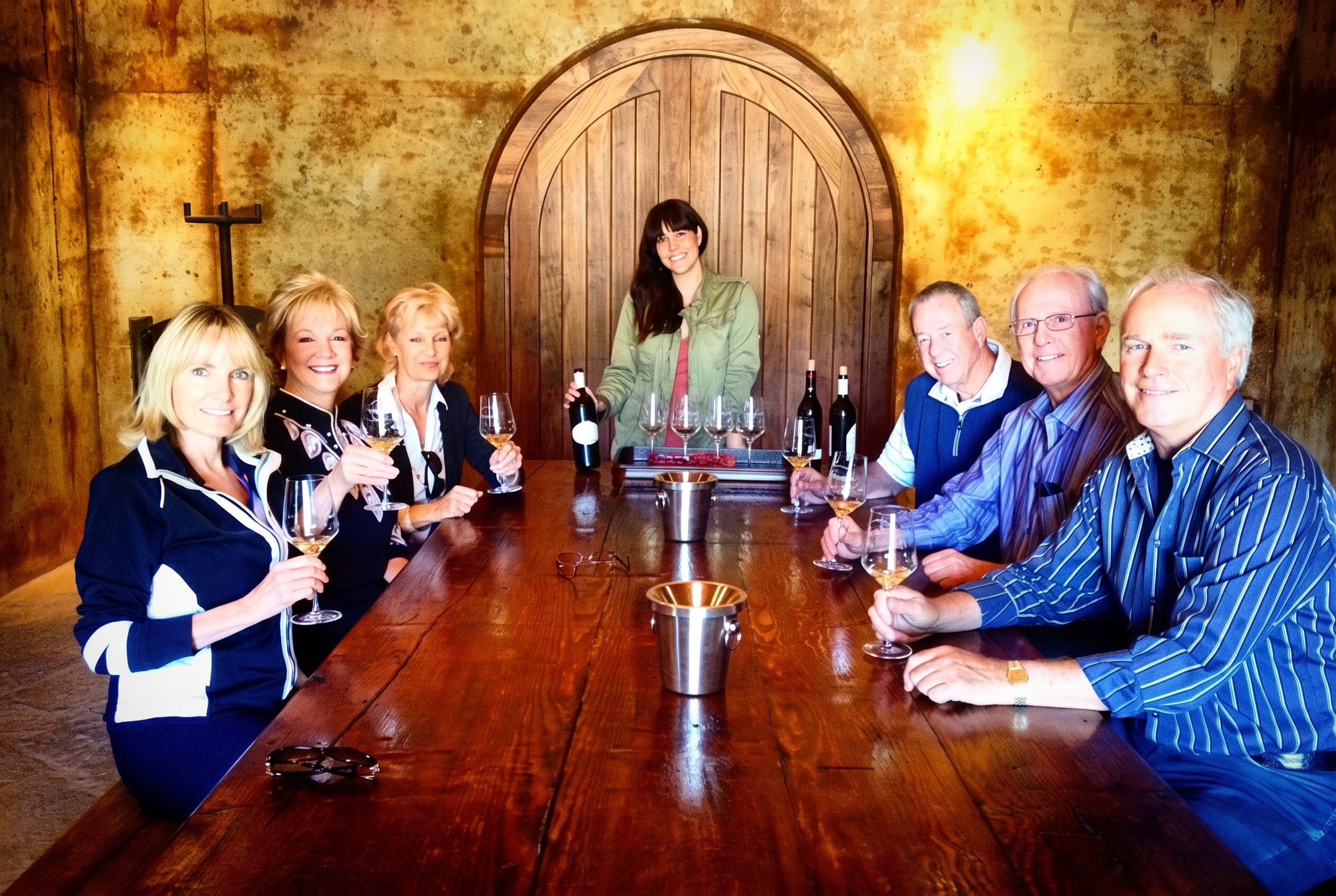 Private wine tasting around a long wooden table inside a wine cave